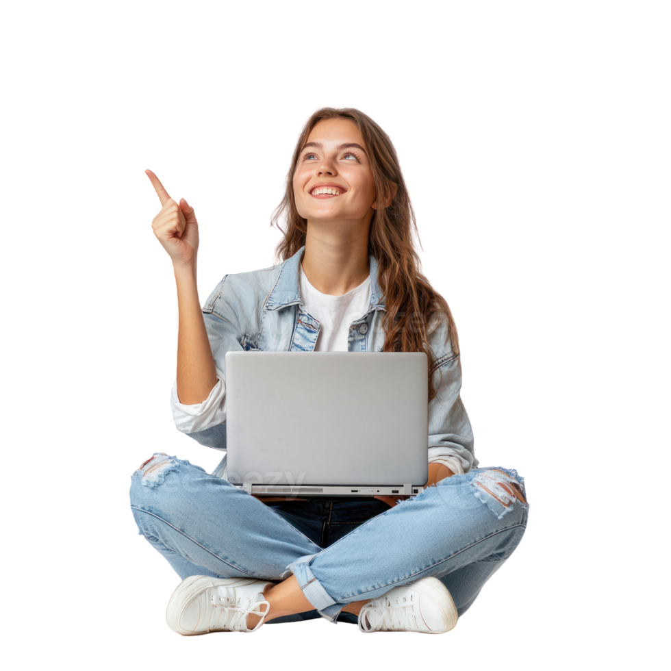 Smiling woman with glasses and curly hair wearing pink hoodie using laptop, sitting cross-legged with hand pointing to right empty space